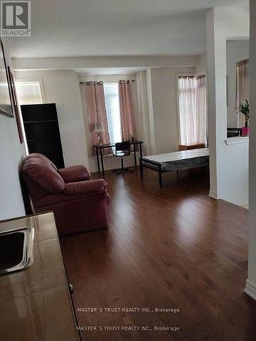 Markham (Berczy) townhouse for rent - A living room with a red chair and a black speaker.