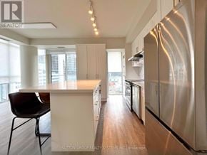 Toronto (Waterfront Communities) condo for rent - A modern kitchen with stainless steel appliances and wooden floors.