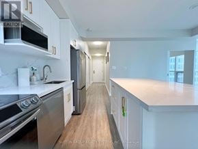 Toronto (Waterfront Communities) condo for rent - A modern kitchen with white cabinets and stainless steel appliances.