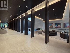 Toronto (Mount Pleasant West) condo for rent - A modern office lobby with a reception desk and a row of black columns.