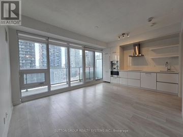 Toronto (Mount Pleasant West) condo for rent - A spacious kitchen with white cabinets and a stainless steel range hood.