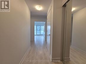 Toronto (Mount Pleasant West) condo for rent - A hallway with a door on the right and a window in the distance.