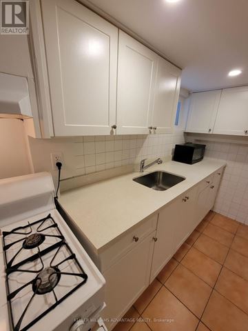 Toronto (Oakwood Village) apartment for rent - A kitchen with white cabinets and a white stove top.