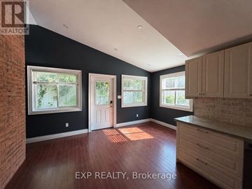 Orangeville duplex for rent - A room with a brick wall and wooden floors.