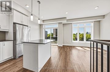 Burlington (Brant) townhouse for rent - A modern kitchen with white cabinets and a black countertop.