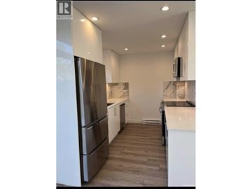 Richmond townhouse for rent - A modern kitchen with a stainless steel refrigerator and wooden flooring.