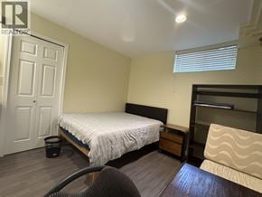 Vancouver apartment for rent - A bedroom with a bed, chair, and a shelf.