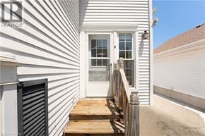 Kitchener apartment for rent - A white house with a wooden deck and a roller shutter door.