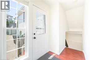 Kitchener apartment for rent - A white door with a black handle is open to a room with white walls and a wooden floor.