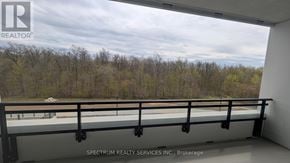 Milton (Cb Cobban) condo for rent - A balcony with a railing and a view of trees and a cloudy sky.