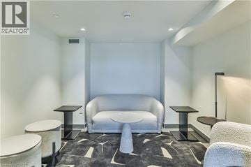 Hamilton condo for rent - A modern living room with a grey sofa and a black and white rug.