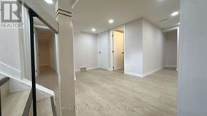 Ottawa apartment for rent - A spacious room with wooden flooring and white walls, with a staircase on the left side.
