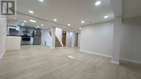 Ottawa apartment for rent - A spacious room with wooden flooring and white walls.