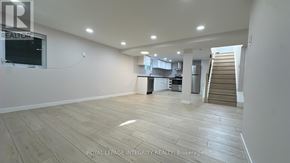 Ottawa apartment for rent - A spacious room with wooden flooring and a staircase in the background.