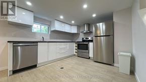 Ottawa apartment for rent - A modern kitchen with stainless steel appliances and white cabinets.