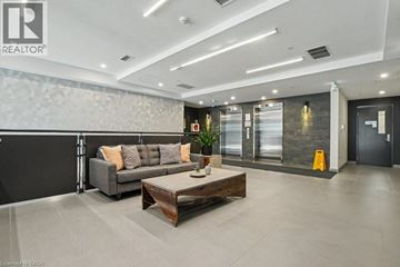 Kitchener condo for rent - A modern living room with a grey sofa and a wooden coffee table.