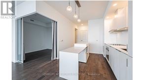 Toronto (Waterfront Communities) condo for rent - A modern kitchen with white cabinets and a wooden floor.