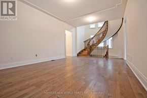 Toronto (Hillcrest Village) apartment for rent - A spacious room with a wooden floor and a spiral staircase.