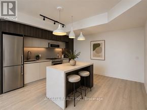 Vaughan (Vaughan Corporate Centre) condo for rent - A modern kitchen with a refrigerator, stove, and bar stools.