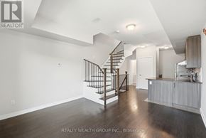 Toronto (Weston) townhouse for rent - A spacious room with a staircase and a kitchen area.