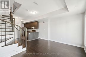 Toronto (Weston) townhouse for rent - A spacious room with a staircase and a cabinet in the background.