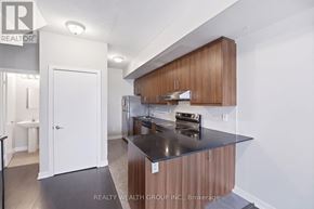 Toronto (Weston) townhouse for rent - A modern kitchen with wooden cabinets and a black countertop.