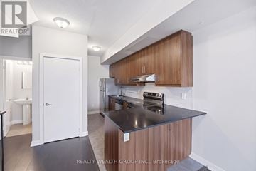 Toronto (Weston) townhouse for rent - A modern kitchen with wooden cabinets and a black countertop.