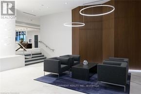 Grimsby (Grimsby Beach) house for rent - A modern living room with a staircase and a grey sofa.