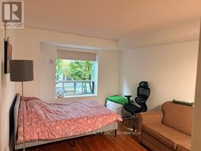 Toronto (Bathurst Manor) condo for rent - A bedroom with a bed, chair, and window.
