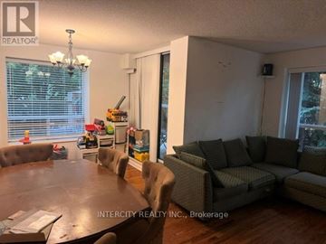 Toronto (Bathurst Manor) condo for rent - A living room with a brown table and grey couches.