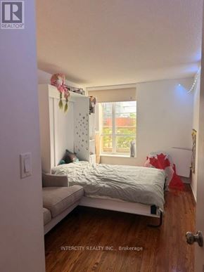 Toronto (Bathurst Manor) condo for rent - A bedroom with a bed, a couch, and a window.