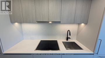 Toronto (North St. James Town) condo for rent - A modern kitchen with a sink and a stove top.