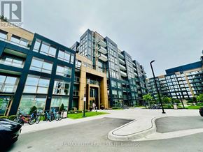 Oakville (Wm Westmount) condo for rent - A modern building with a glass facade and a parking lot in front.