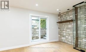 Milton (Tm Timberlea) apartment for rent - A room with a stone wall and a glass door leading outside.