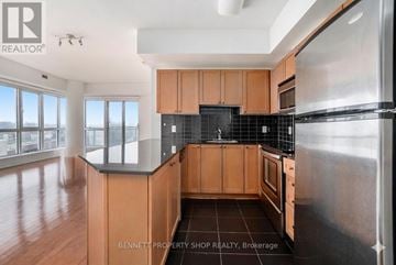 Ottawa condo for rent - A kitchen with wooden cabinets and a black tile backsplash.