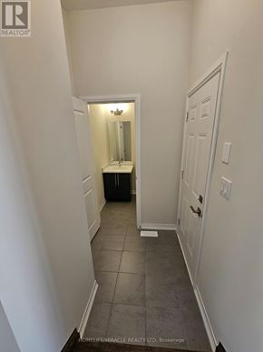 Brantford townhouse for rent - A hallway with a white door and a mirror on the wall.