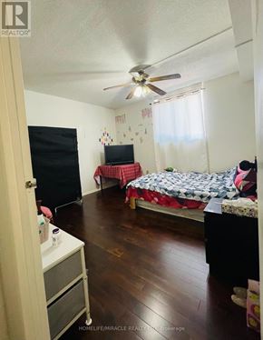Guelph (Willow West/Sugarbush/West Acres) condo for rent - A bedroom with a bed, a dresser, and a ceiling fan.