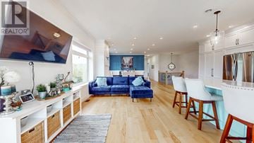 Torbay apartment for rent - A living room with a blue couch and a white dining table.