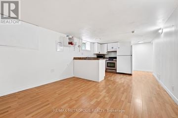 Whitby (Williamsburg) apartment for rent - A spacious kitchen with white cabinets and a wooden floor.
