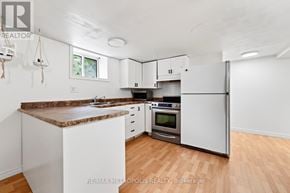 Whitby (Williamsburg) apartment for rent - A kitchen with white cabinets and a brown granite countertop.