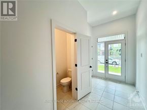 Ottawa townhouse for rent - A white bathroom with a toilet and a door leading to a balcony.