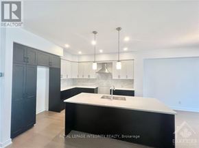 Ottawa townhouse for rent - A modern kitchen with a large island and dark cabinets.