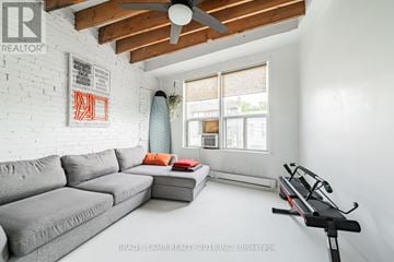 Toronto (Little Portugal) apartment for rent - A living room with a grey couch and a black exercise bike.
