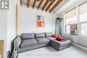 Toronto (Little Portugal) apartment for rent - A living room with a grey couch and a white brick wall.