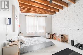 Toronto (Little Portugal) apartment for rent - A white bedroom with a bed, nightstand, and window.
