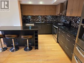 Richmond Hill (North Richvale) condo for rent - A kitchen with a black counter top and wooden floors.