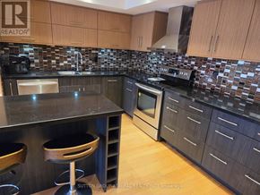 Richmond Hill (North Richvale) condo for rent - A kitchen with a black counter top and wooden cabinets.