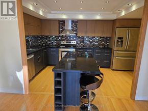 Richmond Hill (North Richvale) condo for rent - A kitchen with a black counter top and wooden cabinets.