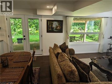 Kitchener apartment for rent - A living room with a brown couch and a painting on the wall.