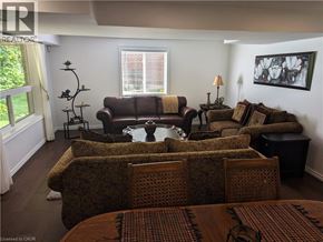 Kitchener apartment for rent - A living room with a brown sofa and a table with a vase on it.
